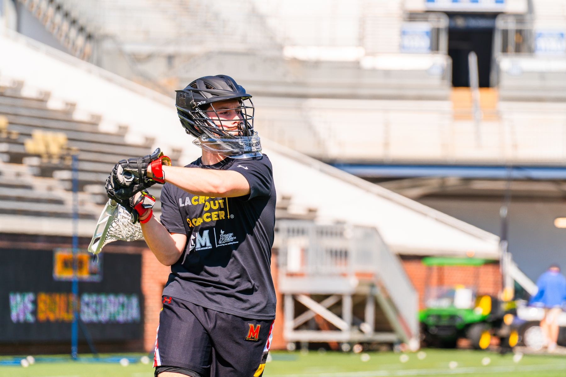 Maryland player warming up in a LaCROSSe Out Cancer shirt at Bobby Dodd Stadium